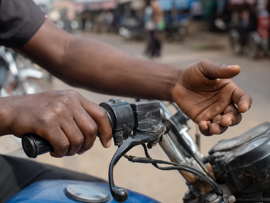 Hands gripping okada handlebars, showing how wrist strain builds during manual work